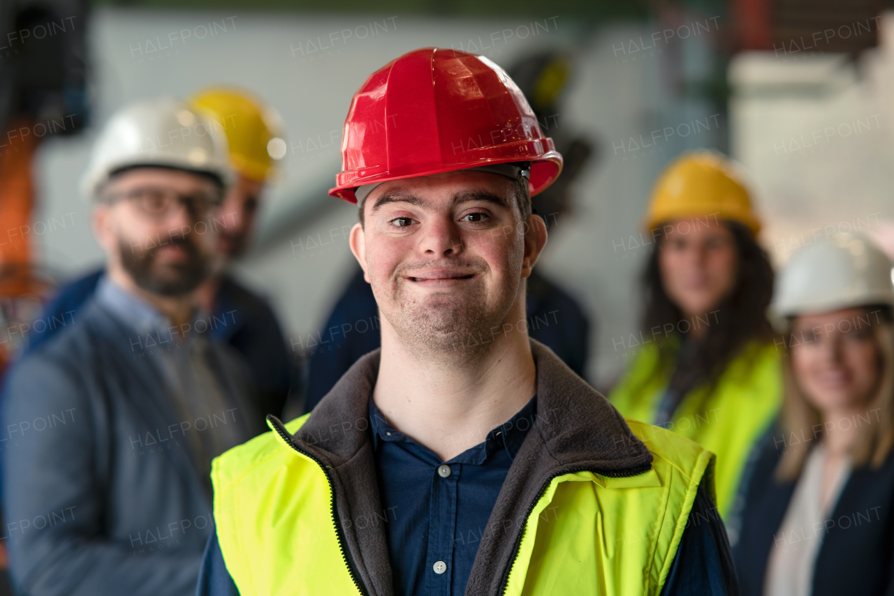 A young man with Down syndrome working in industrial factory, social integration concept.