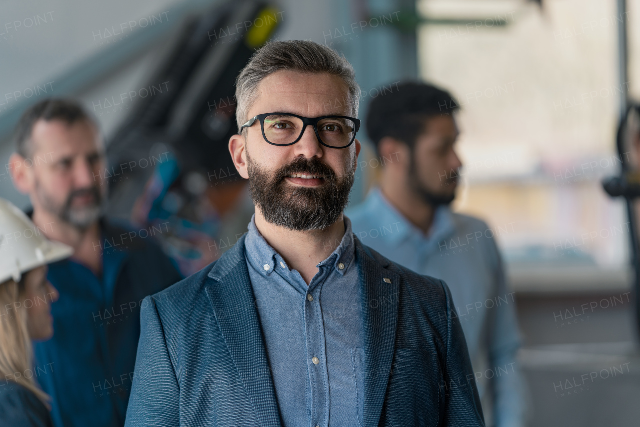 A portrait of male chief engineer in modern industrial factory looking at camera.