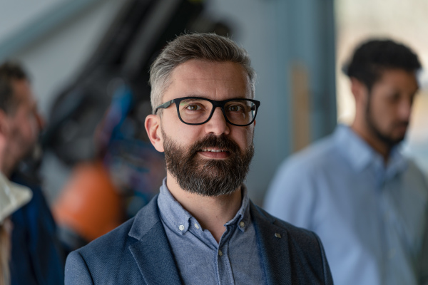 A portrait of male chief engineer in modern industrial factory looking at camera.