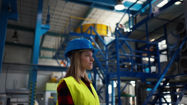 A woman worker woring in industrial factory, programming machine.