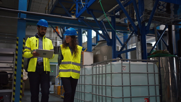 A portrait of female chief engineer in modern industrial factory using tablet.