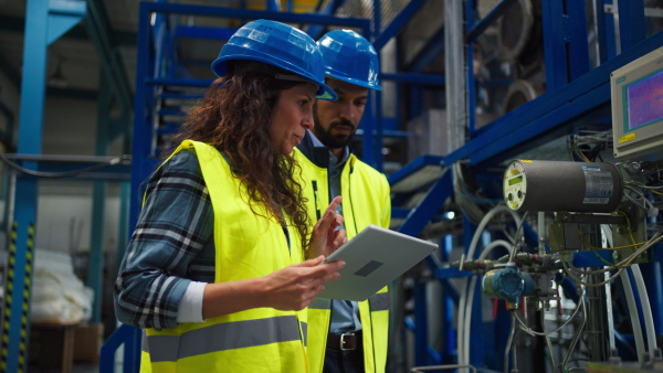 A portrait of female chief engineer in modern industrial factory using tablet.