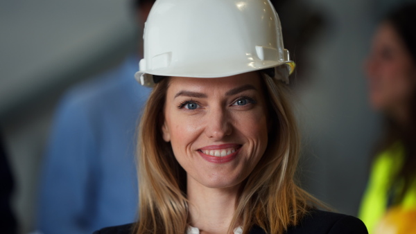 A portrait of female chief engineer in modern industrial factory using tablet.