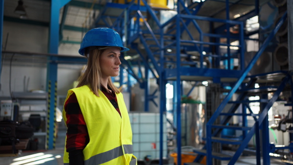 A woman worker woring in industrial factory, programming machine.