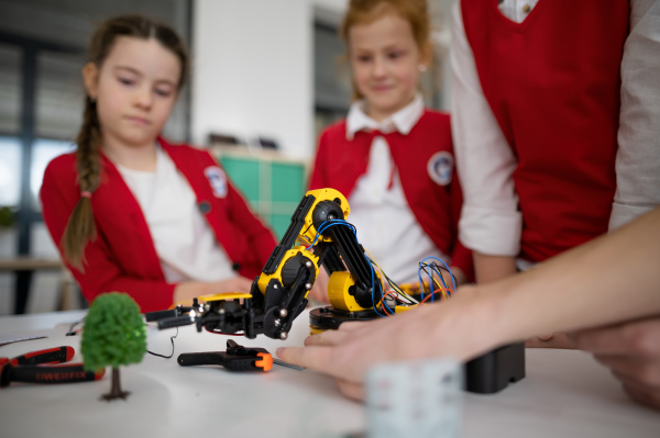 A group of kids programming electric toys and robots at robotics classroom