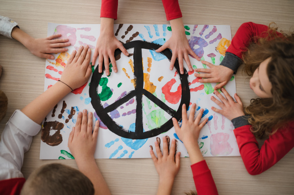 A top view of children making a poster of peace sign at school.