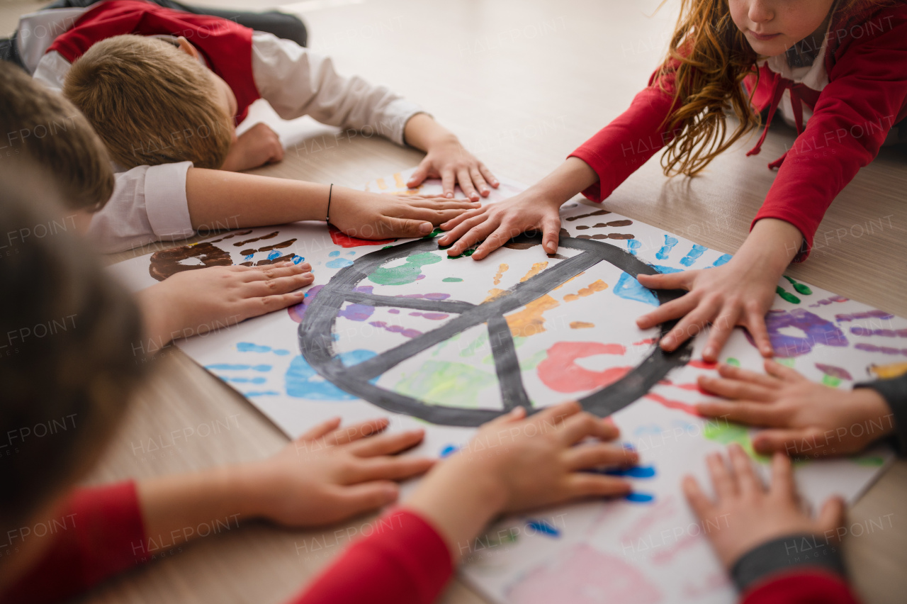 Schoolchildren making a poster of peace sign at school.