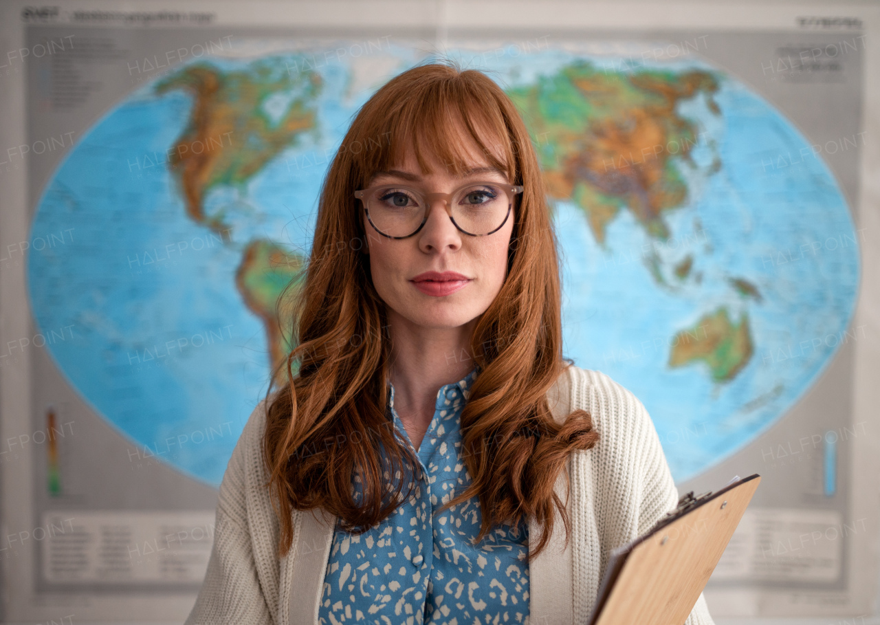 A portrait of young geography teacher looking at camera in classroom