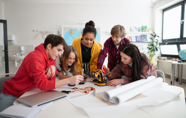 A group of students building and programming electric toys and robots at robotics classroom