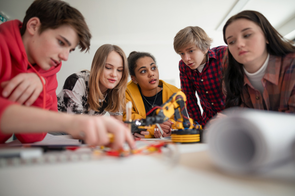 A group of students building and programming electric toys and robots at robotics classroom