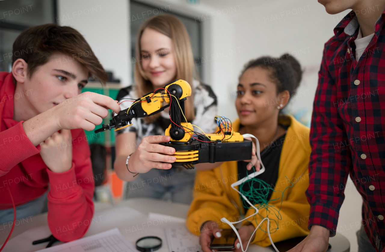 A group of students building and programming electric toys and robots at robotics classroom