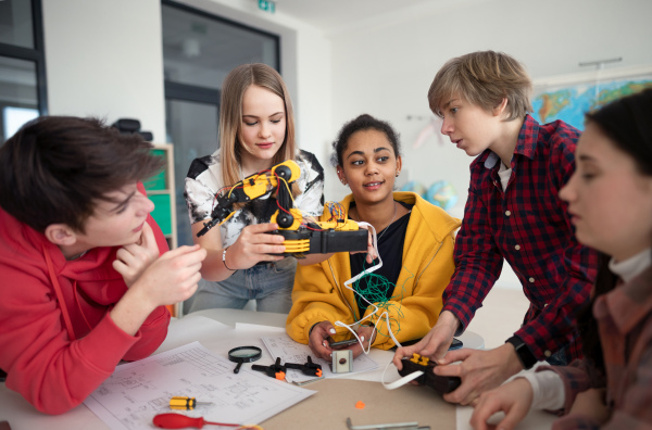 A group of students building and programming electric toys and robots at robotics classroom