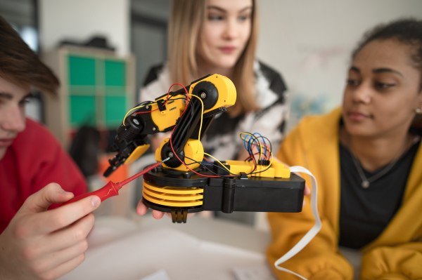 A group of students building and programming electric toys and robots at robotics classroom