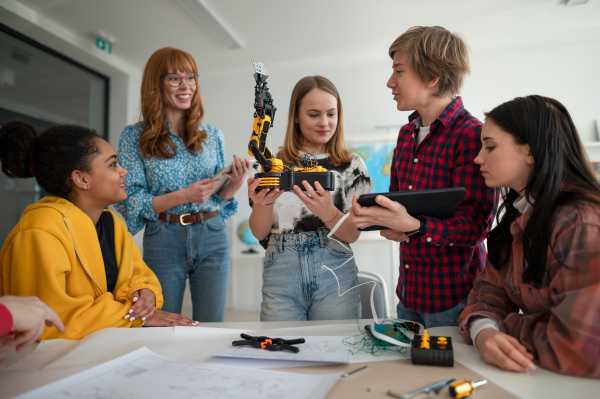 A group of students building and programming electric toys and robots at robotics classroom