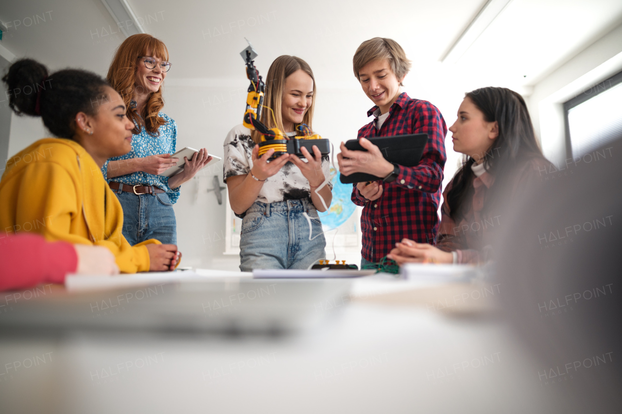 A group of students building and programming electric toys and robots at robotics classroom