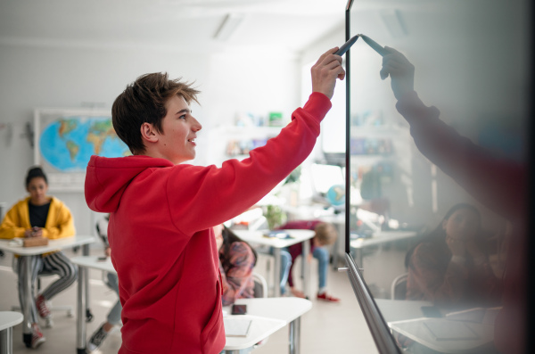 A college student explaining some ideas on a touch TV in classroom.