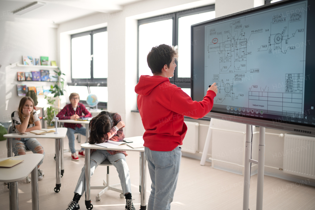 A college student explaining some ideas on a touch TV in classroom.