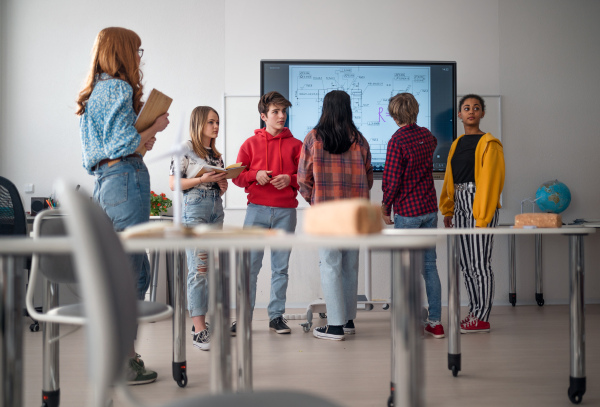 A college student explaining some ideas on a touch TV in classroom.