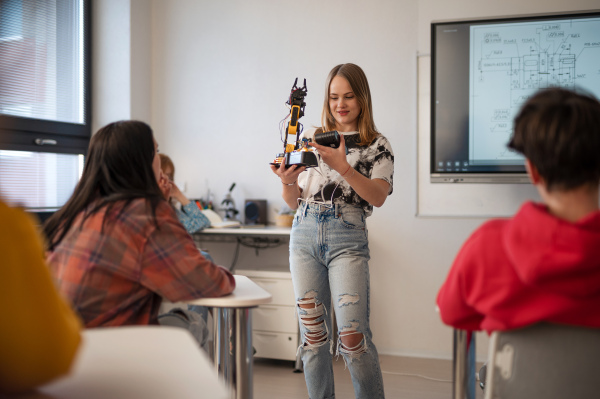 Young High school student is presenting her robotic project in a classroom