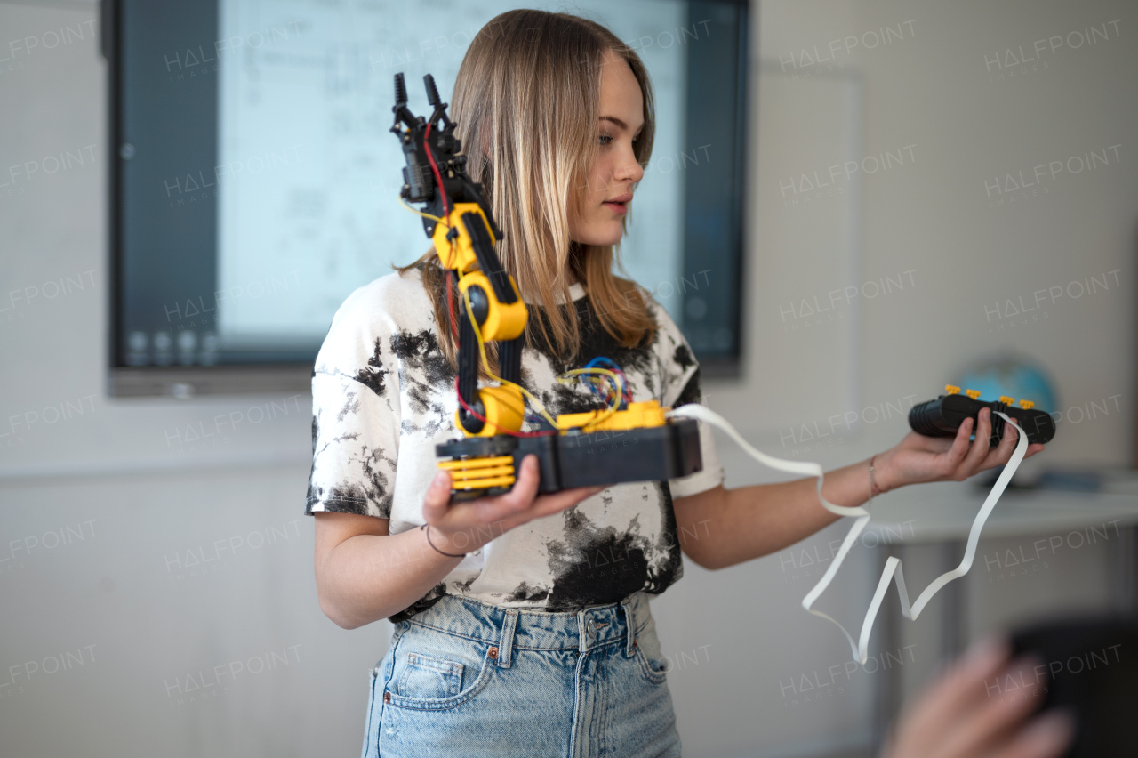 Young High school student girl is presenting her robotic project in a classroom