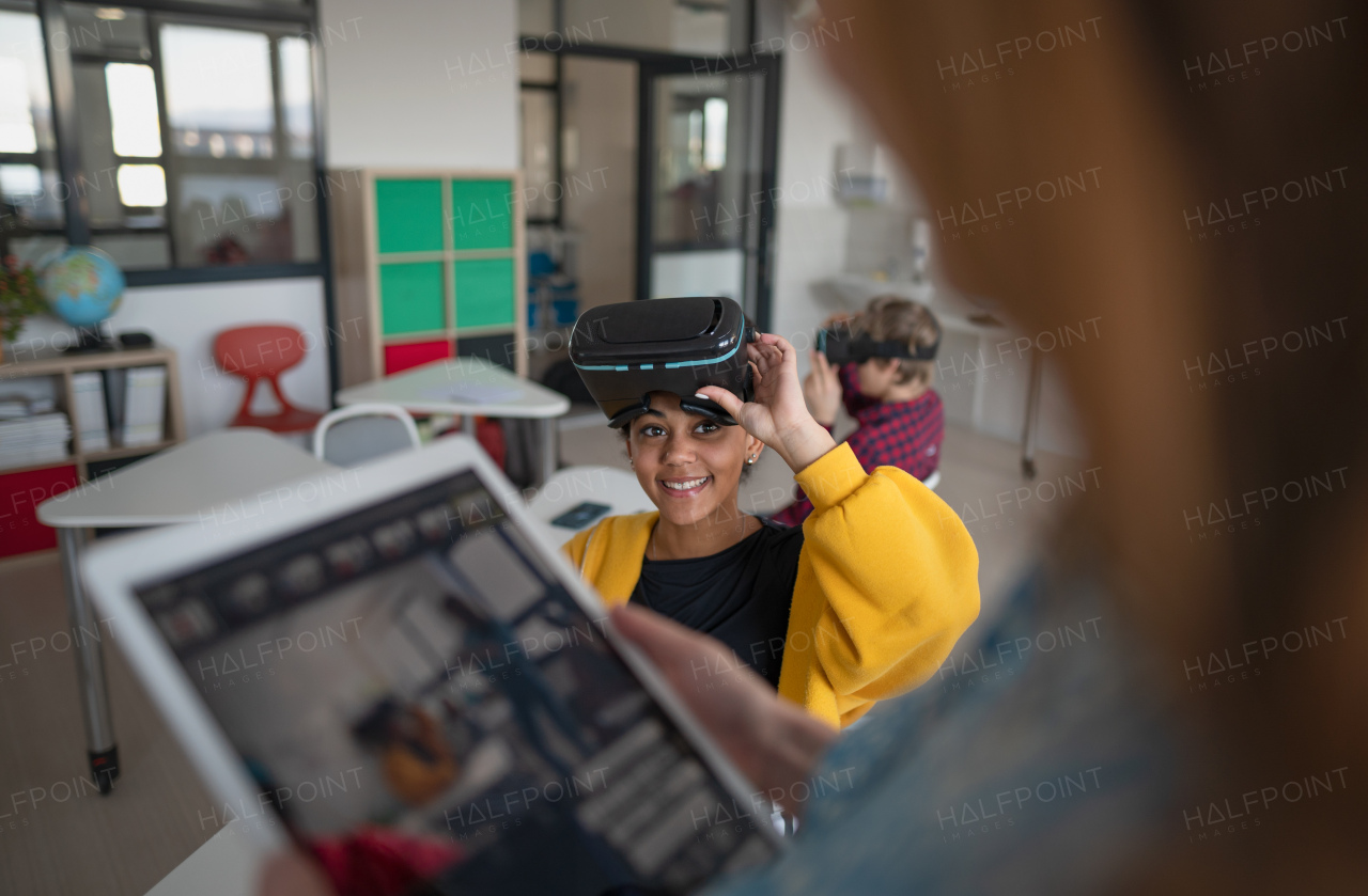 Happy students wearing virtual reality goggles at school in a computer science class