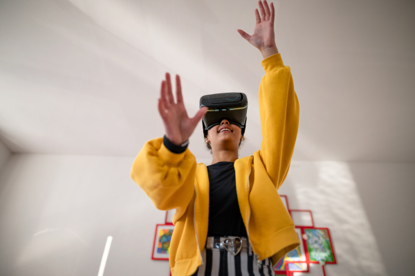 A happy student wearing virtual reality goggles at school in computer science class