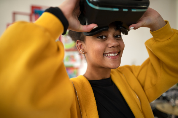 A happy student wearing virtual reality goggles at school in computer science class