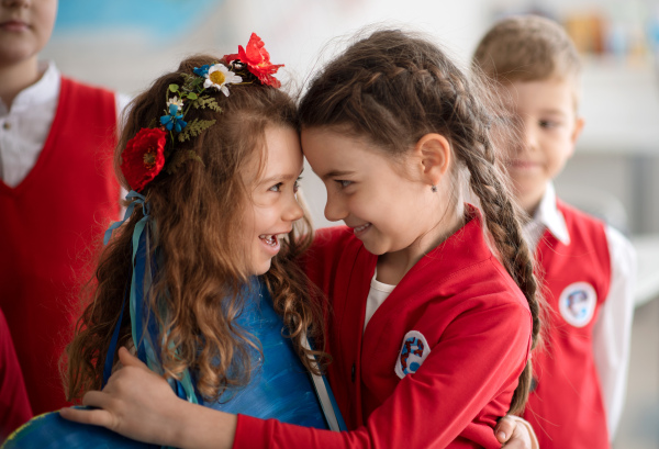 Schoolchildren welcoming a new Ukrainian classmate, concept of enrolling Ukrainian kids to schools.