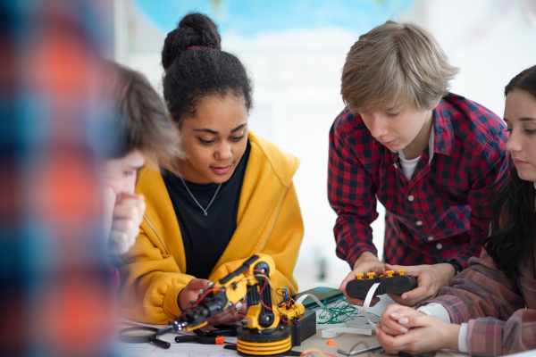 A group of students building and programming electric toys and robots at robotics classroom