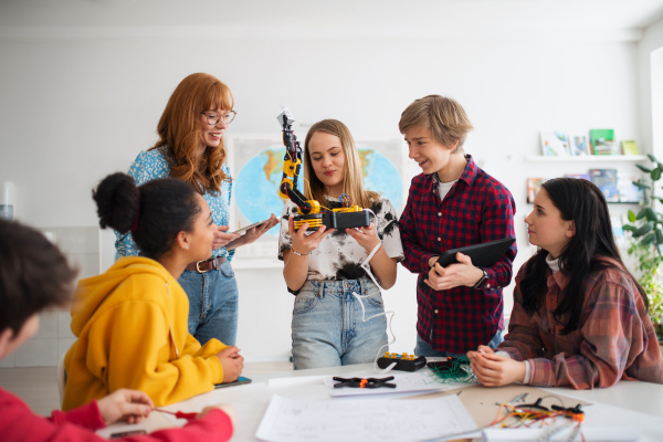 A group of students building and programming electric toys and robots at robotics classroom