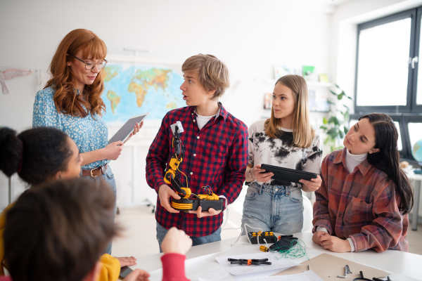 A group of students building and programming electric toys and robots at robotics classroom