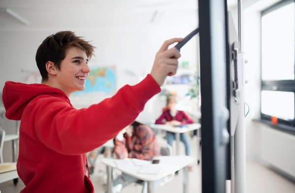 A college student explaining some ideas on a touch TV in classroom.