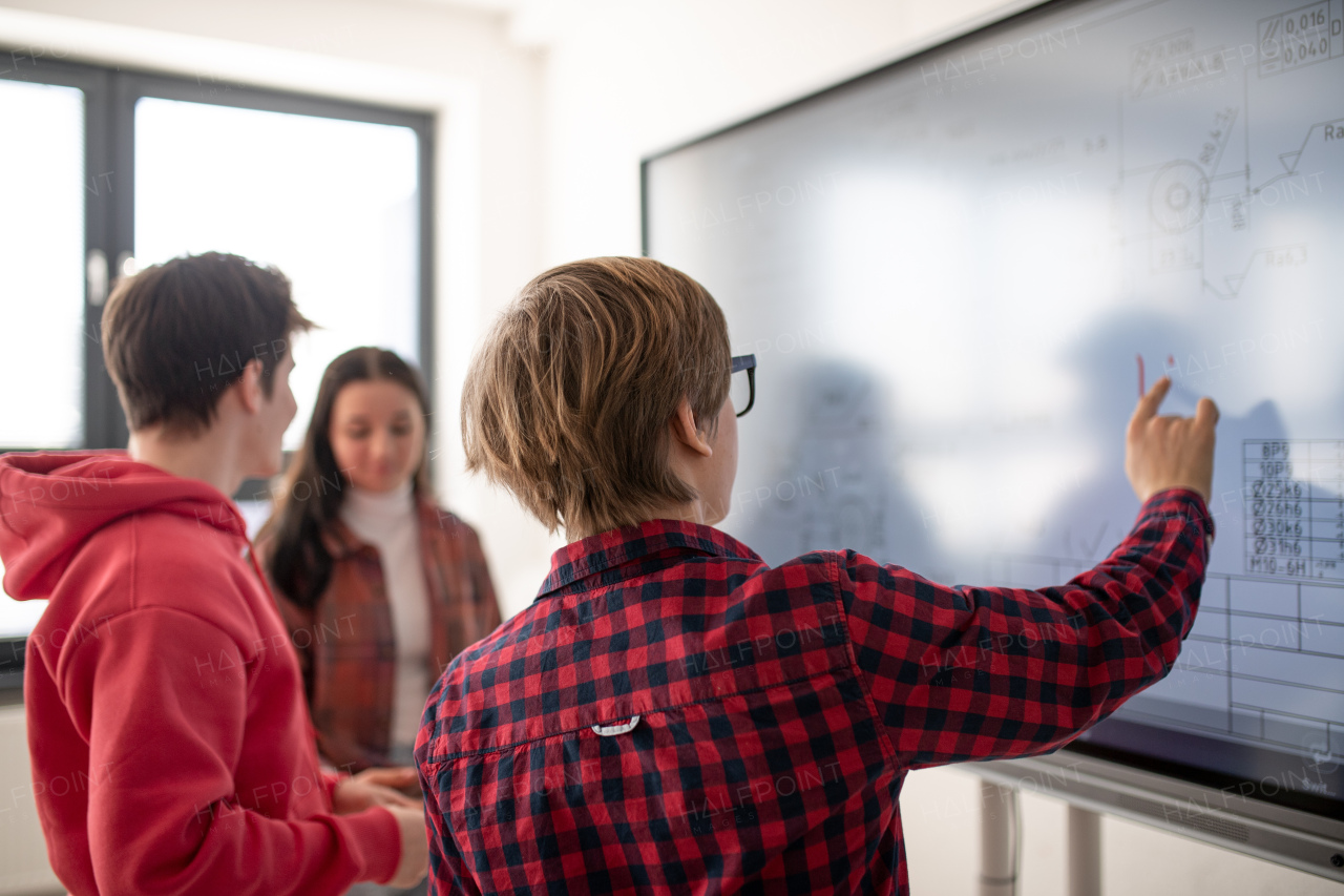 A college student explaining some ideas on a touch TV in classroom.