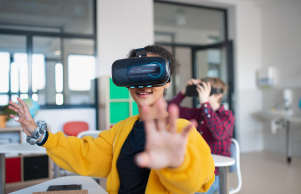 Teenage students wearing virtual reality goggles at school in a computer science class