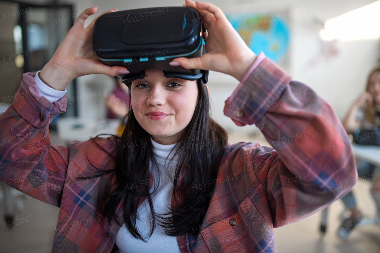 A happy student wearing virtual reality goggles at school in computer science class