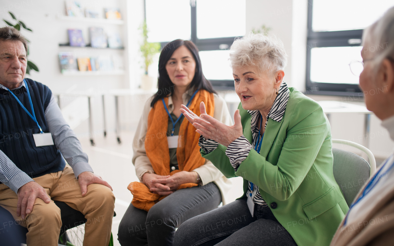 A group of senior people sitting in circle and discussing some problems together during therapy session