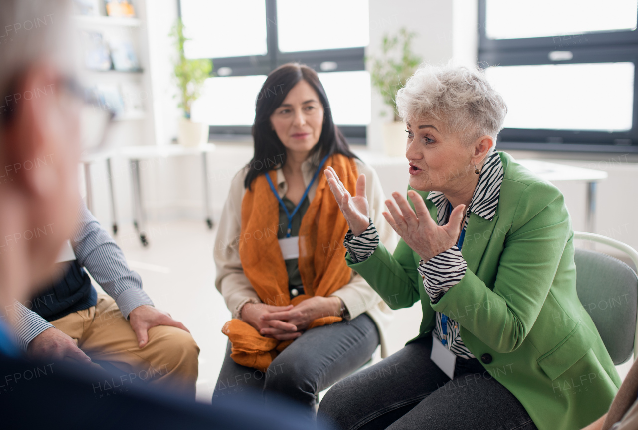 A group of senior people sitting in circle and discussing some problems together during therapy session