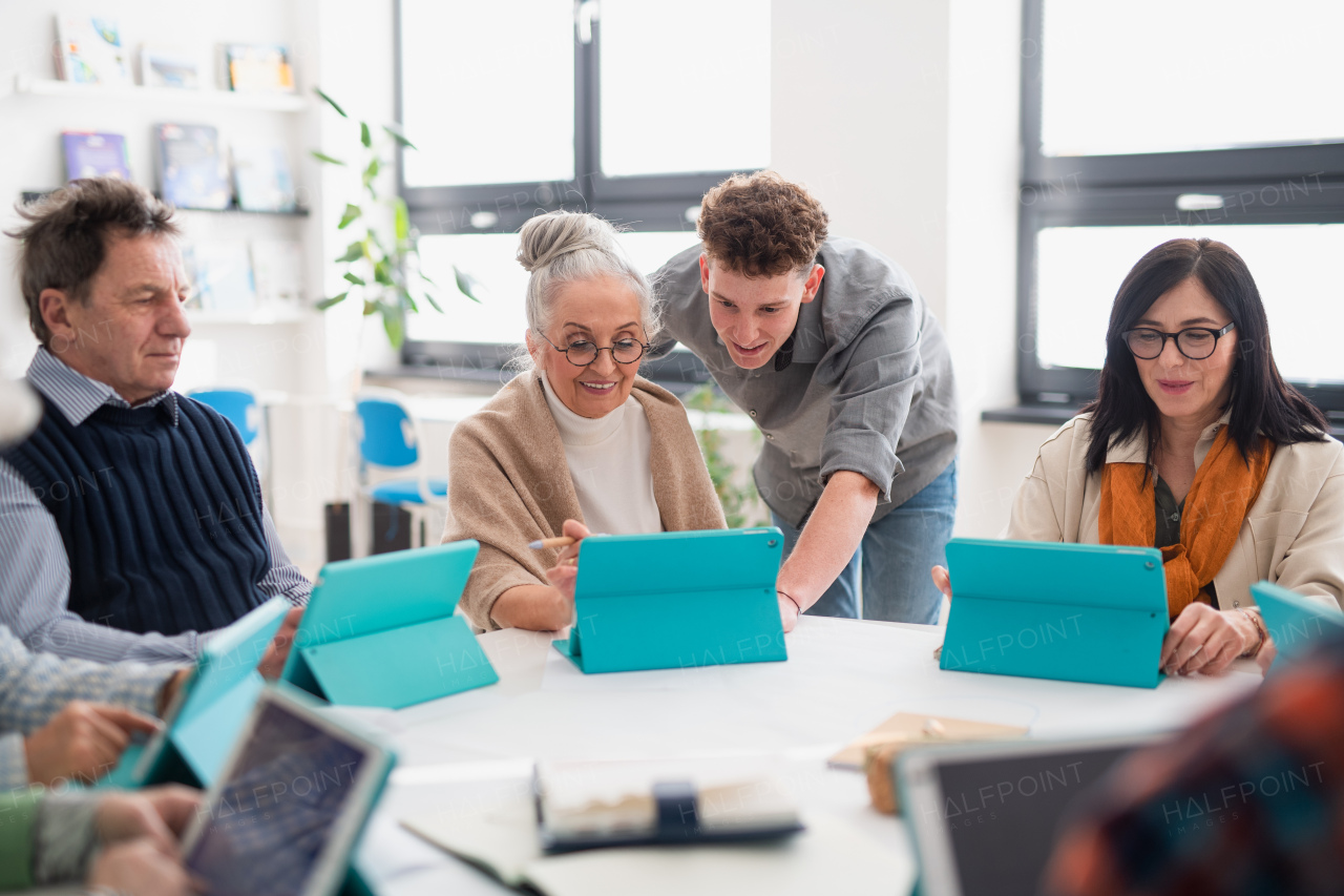 A group of seniors attending IT class in community centre with teacher