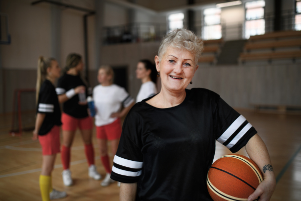 Senior woman posing with a basketball ball before womans match.