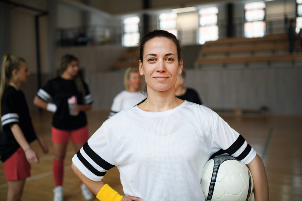 Young woman posing with a basketball ball before womans match.