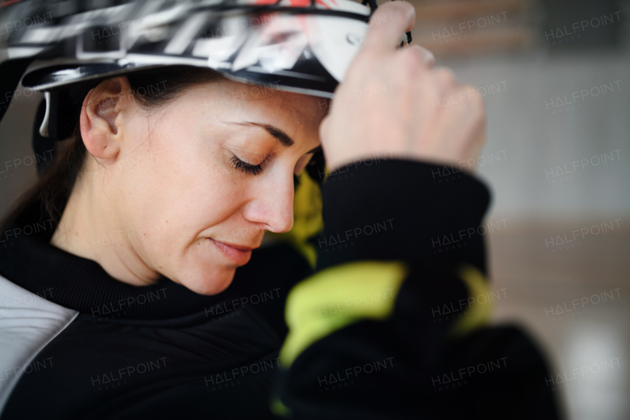 A close-up of woman floorball goalkeeper in helmet concetrating on game in gym.