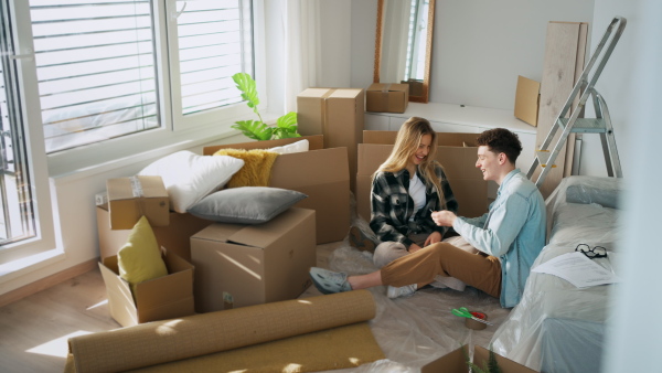 A cheerful young couple in their new apartment. Conception of moving.