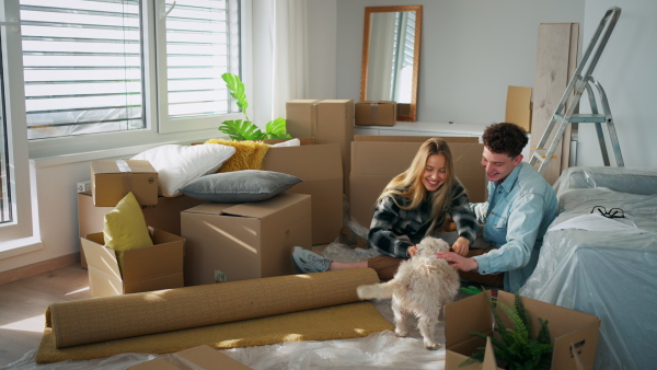 A cheerful young couple in their new apartment. Conception of moving.