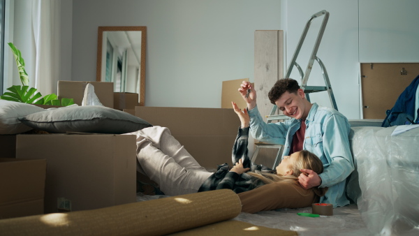 A cheerful young couple in their new apartment. Conception of moving.