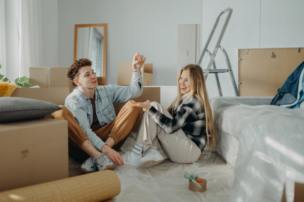 A cheerful young couple in their new apartment. Conception of moving.