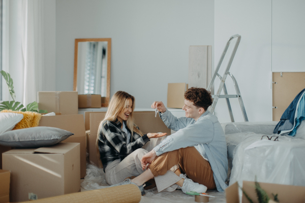 A cheerful young couple in their new apartment. Conception of moving.