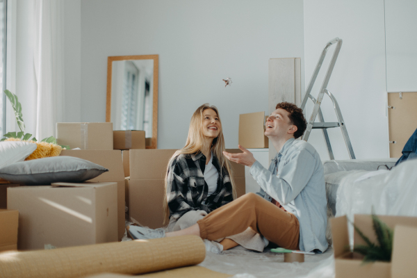 A cheerful young couple in their new apartment. Conception of moving.