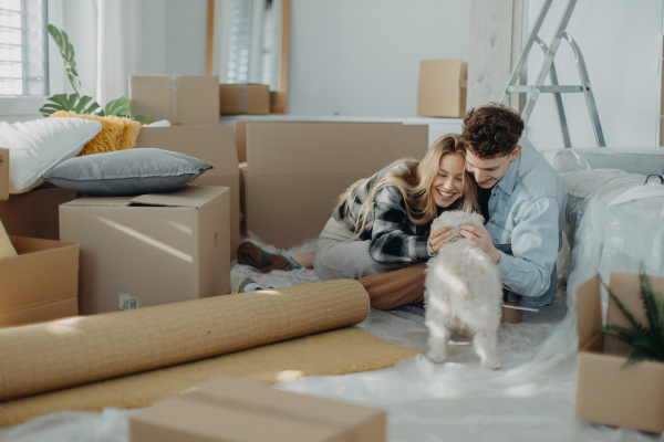 A cheerful young couple in their new apartment. Conception of moving.