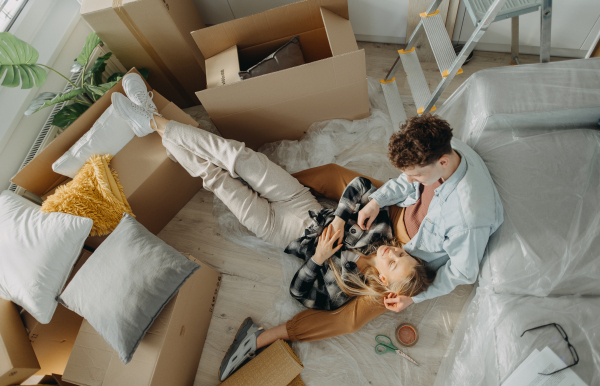 A top view of cheerful young couple in their new apartment. Conception of moving.