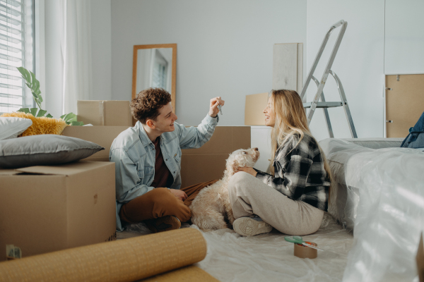 A cheerful young couple in their new apartment. Conception of moving.